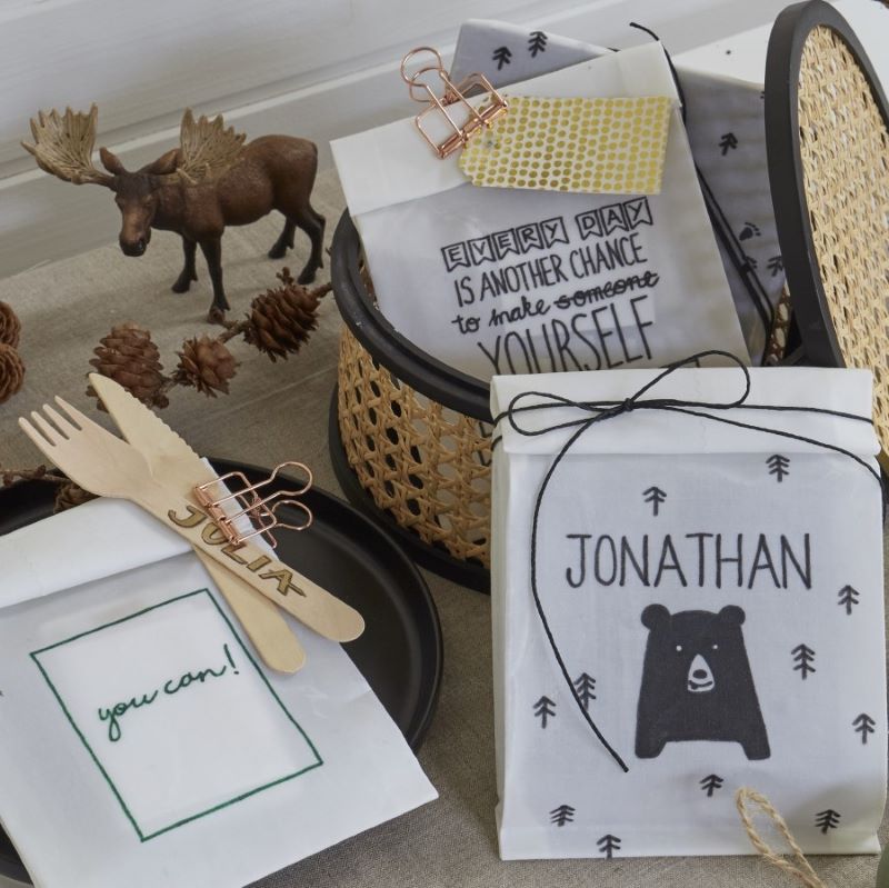 vier gewachste Stoff-Tüten auf dem Esstisch dekoriert