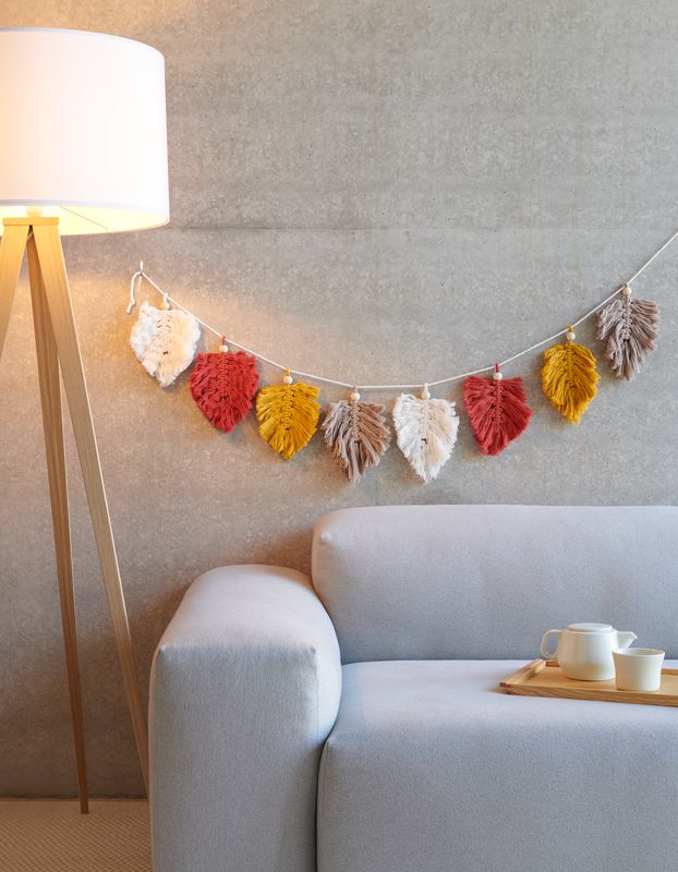 geknüpfte Blätter in creme, braun, rot und gelb, als Girlande aufgehängt