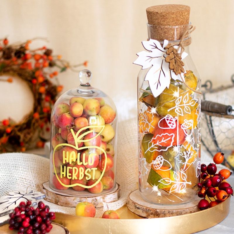 Zwei herbstlich verzierte Glasgefäße mit weißem und gelbem Lackstift bemalt